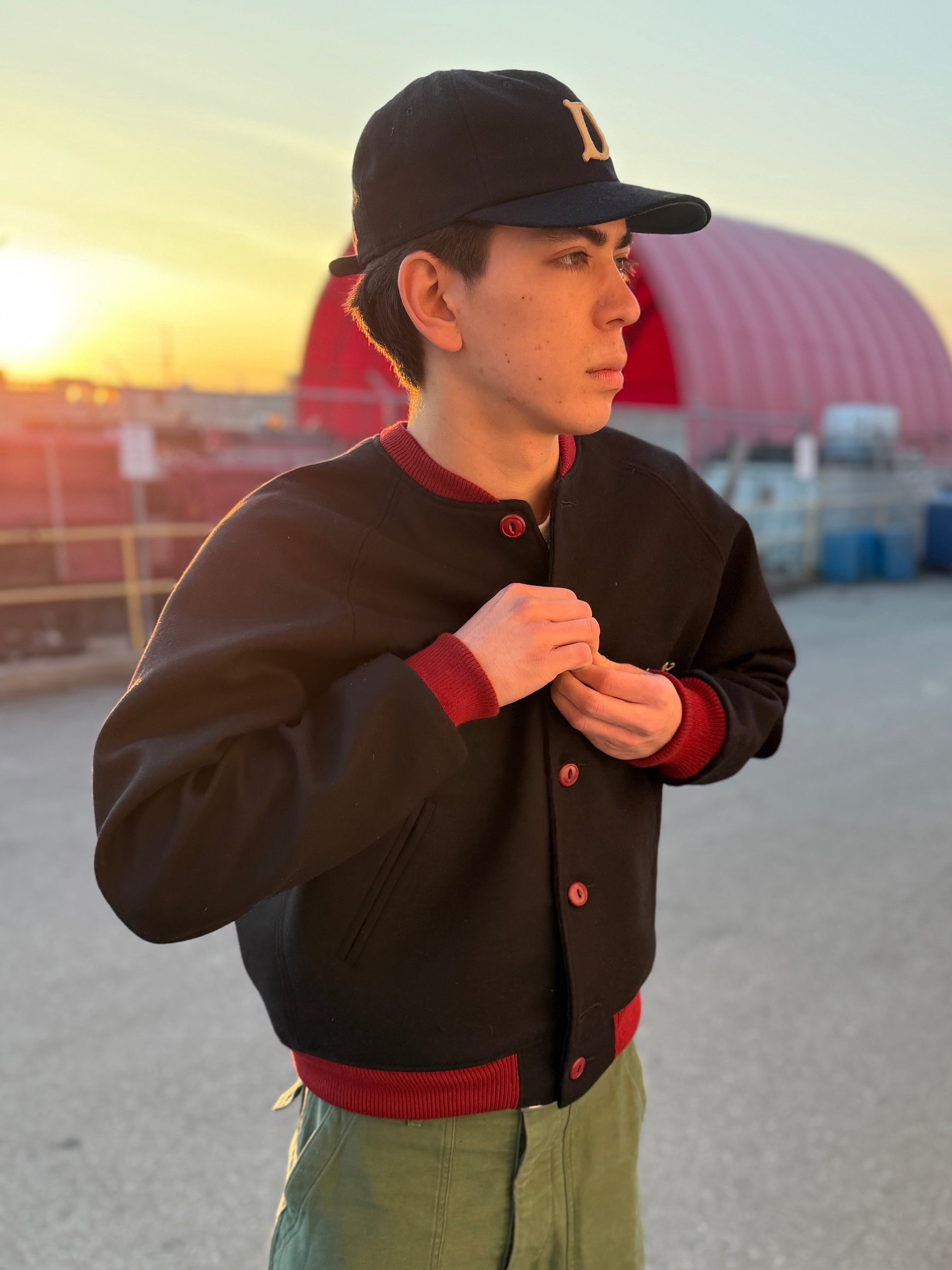 Emerson is putting on the black varsity jacket. 