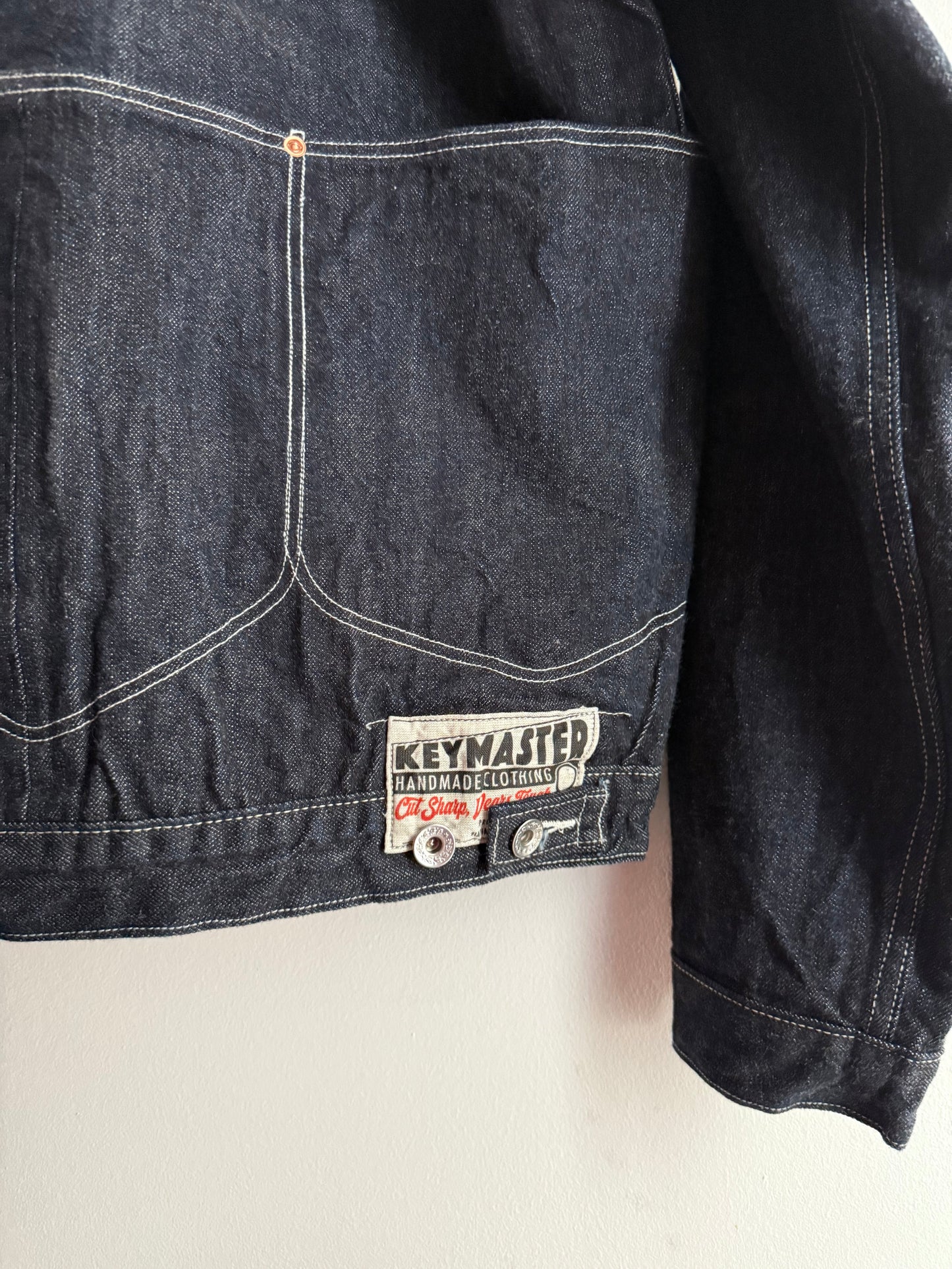 Dark blue denim jeans with a brand label on a light background